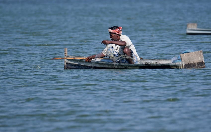 A fisherman pulling out his gill net after several hours of fishing in the Ganga river, West Bengal.