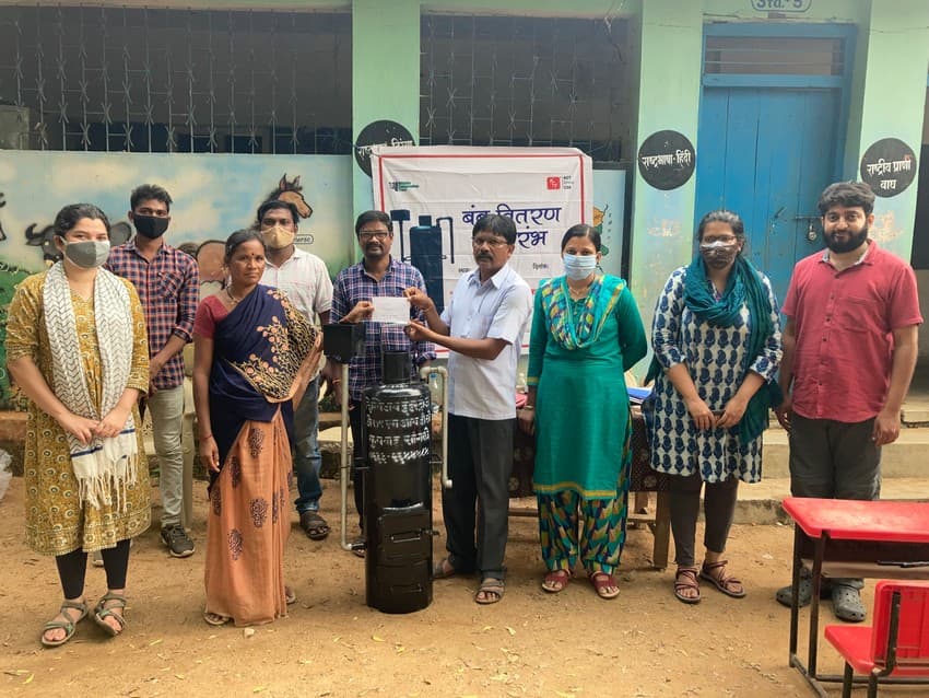 The thousandth beneficiary receives her water heater as the Conservation Behaviour team comes together for the distribution.