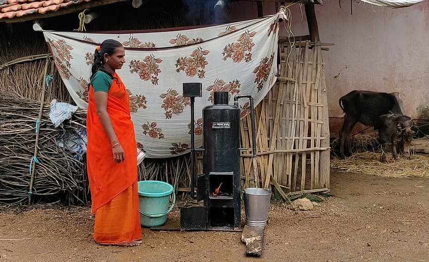 A girl uses a firewood-fuelled chulha to heat water. Firewood burning has adverse health effects.