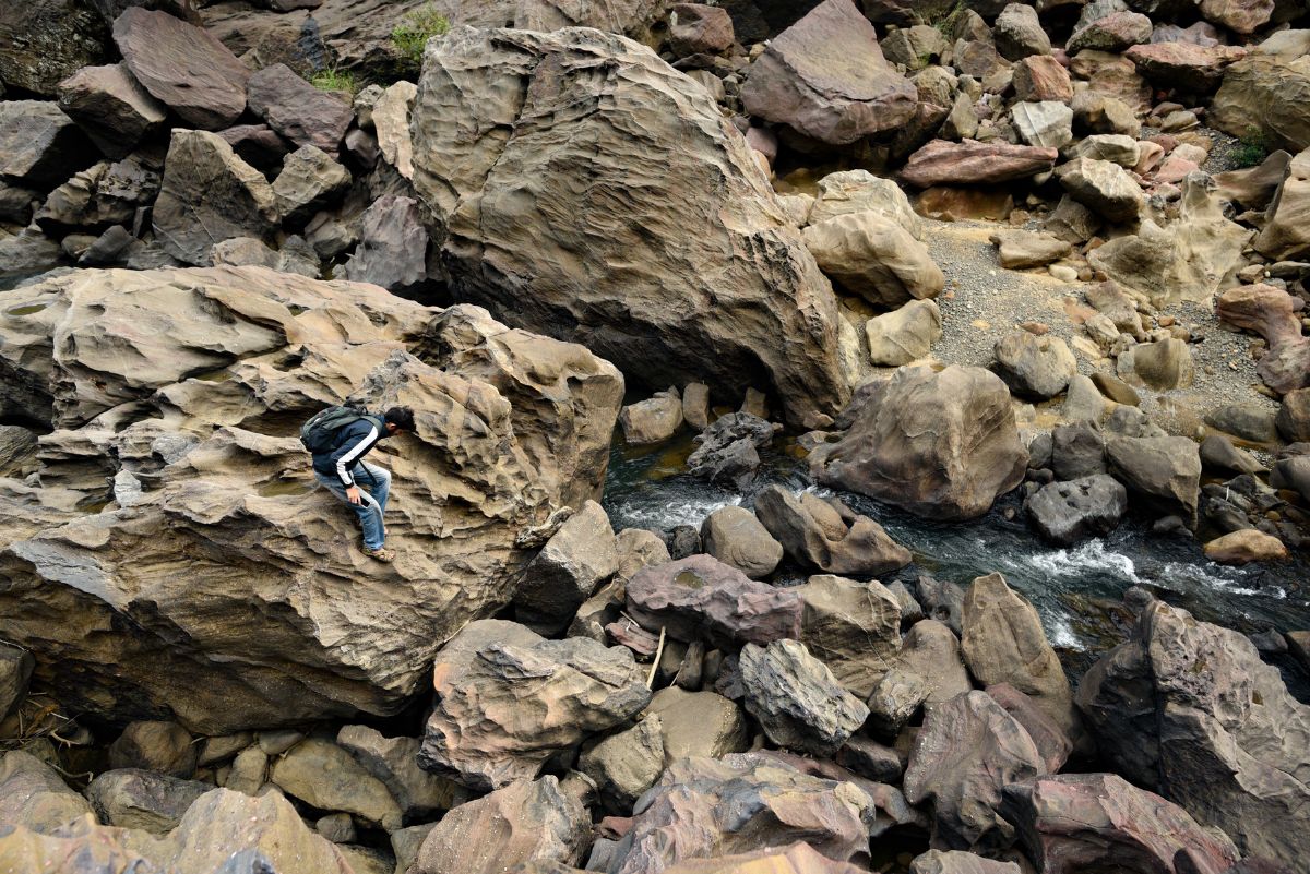 Many remote hill streams of the Satpura Tiger Reserve are marked by gigantic boulders strewn haphazardly with clear water gurgling through them. A team member navigating through them provides a scale to gauge the size of these boulders.